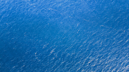 Vibrant blue waves dance under the sunlight, creating a mesmerizing turquoise expanse that touches the horizon