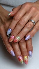 Colorful floral nail art on female hands with silver rings