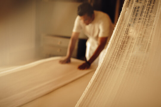 Professional housekeeping staff preparing a luxurious villa bedroom with neatly folded linens