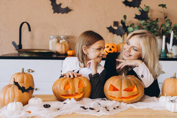 Mother and daughter carving pumpkins for Halloween party