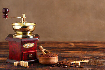 Grinder and bowl with coffee powder on wooden background, closeup © Pixel-Shot