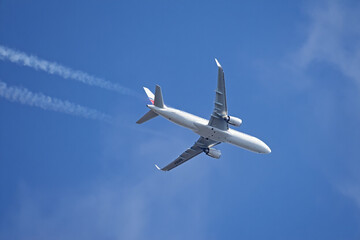 Commercial Airplane Flying in Clear Blue Sky Leaving Vapor Trails Behind Travel and Transportation...