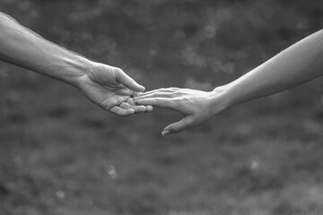 Hands of male and female holding together. Woman and man holding hands together. Giving a helping...