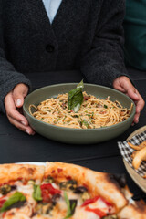 Woman holding a bowl of Spaghetti Carbonara from an Australian cafe.