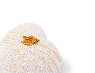 Intricate dessert with gold leaf detail showcased on white background