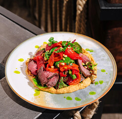 Vibrant roasted meat dish topped with herbs and vegetables served beautifully
