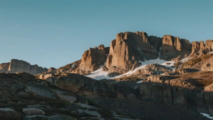 Obraz premium Rugged Mountain Landscape with Snowy Patches Under Clear Sky