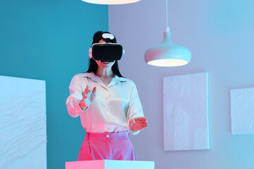Young woman with VR glasses near pedestal in modern art gallery