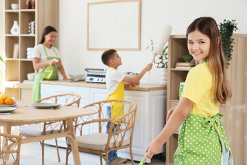 Fototapeta premium Teenage girl with her family cleaning in kitchen