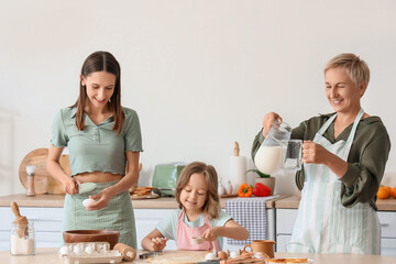 Little girl with her mother and granny making cookies in kitchen