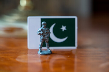A tin soldier on the background of the flag of Pakistan. India Pakistan military conflict