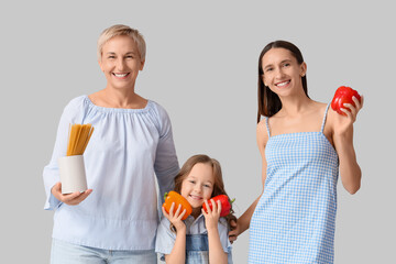 Happy family with pasta and bell peppers on light background