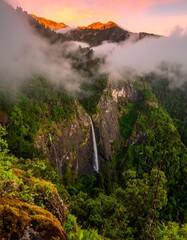 Misty mountain waterfall at dawn