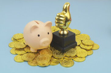 Piggy bank and thumbs up on gold coins. Best saving concept.