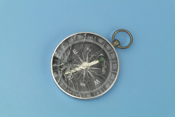 Broken compass on blue background.  © Valerii Evlakhov
