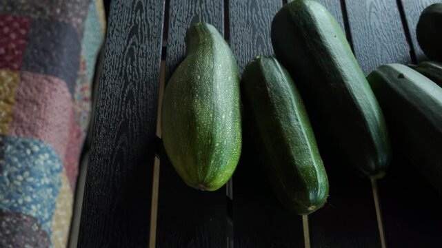 Freshly harvested zucchinis displayed on a wooden surface ready for cooking or sale