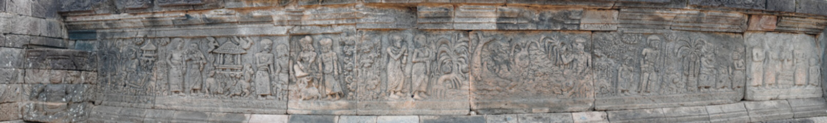 A panoramic view of ancient stone relief carvings depicting figures on architectural walls