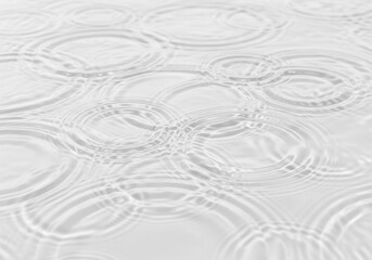 Clear water surface with delicate ripples forming concentric circles. This clean, minimalist...