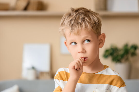Little boy biting nails at home, closeup