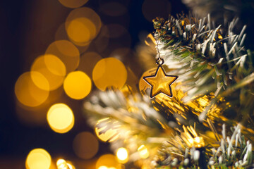 Christmas tree toy in the form of a golden star  on a branch. Christmas and New Year decoration,...