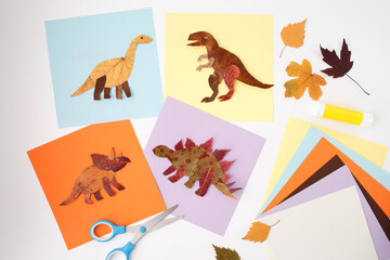 Leaves clip arts with scissors on table, paper cutout process art of Spinosaurus dinosaur, fall kids craft activity, image useful for toy brands, school education, art and craft supply shops,
