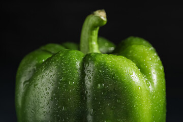 Green bell pepper on black background, closeup