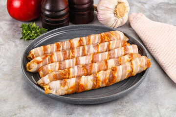 Raw sausages wrapped in bacon