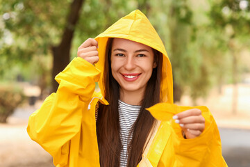 Young woman with yellow raincoat in park
