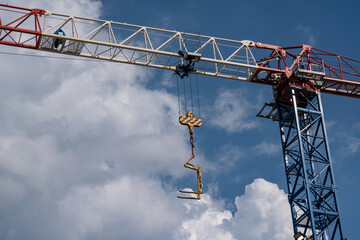 Construction crane with load forks in action, a symbol of efficiency and work in the construction industry. Ideal for illustrating articles and projects on the construction industry and logistics.