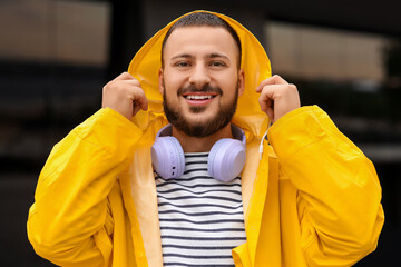 Young man in yellow raincoat outdoors