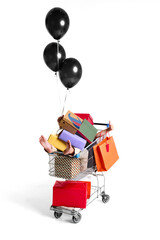 Shopping cart filled with colorful gift boxes and balloons on white background. Concept of seasonal...