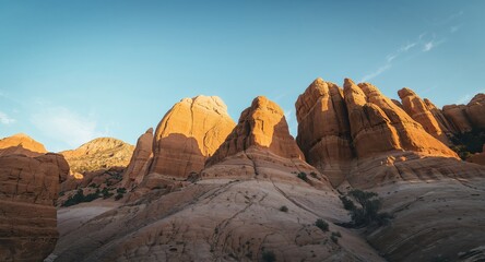 Fototapeta premium Sandstone Giants. A LowAngle View of Majestic Red Rock Formations Against Blue Sky