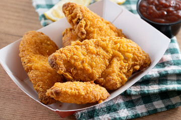 Crispy fried chicken tenders on wooden table