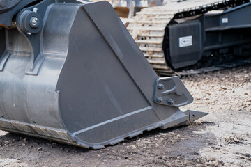 Large excavator bucket edge closeup, heavy-duty construction tool for soil and gravel excavation, robust machinery attachment detail, industrial earthmoving equipment on outdoor work site