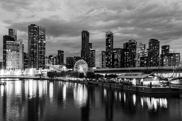 Obraz premium Melbourne, Victoria, Australia - 19 April 2025 : South Wharf Promenade at twilight on the banks of the river Yarra in black and white