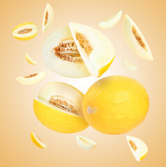 Tasty ripe melons swirling in air against beige gradient background