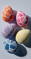 Five colorful, geometric Easter eggs.  Each egg features a pattern of translucent,  interlocking shapes in a gradient of  pastel hues