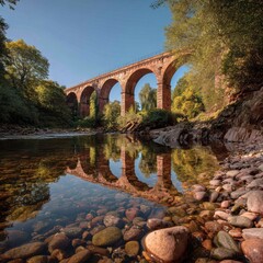 Tranquil river reflecting an ancient railway bridge