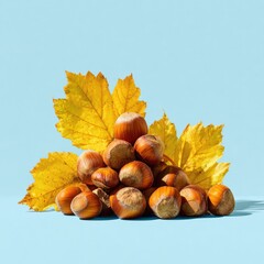 Hazelnuts nestled amongst vibrant autumn leaves on a pale blue surface