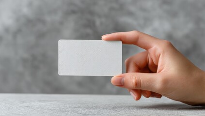 A blank white business card held by a hand