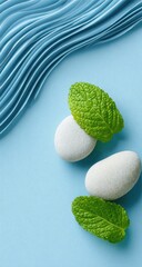 Light-blue background with smooth, wavy lines, and three white stones with fresh green mint leaves