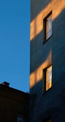 Obraz premium Sunlight casts long shadows on apartment building at dawn/dusk