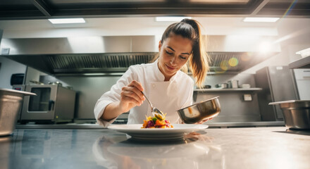 Female chef plating a gourmet dish in a professional kitchen. Young cook preparing a meal with precision and care.