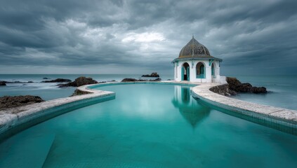 Coastal pool with a small, domed structure.  Dramatic sky