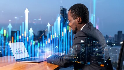 Successful African American businessman analyzing financial data on a laptop in the office at night - Powered by Adobe