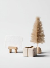 Minimalist Christmas scene with a card, small tree, and gift