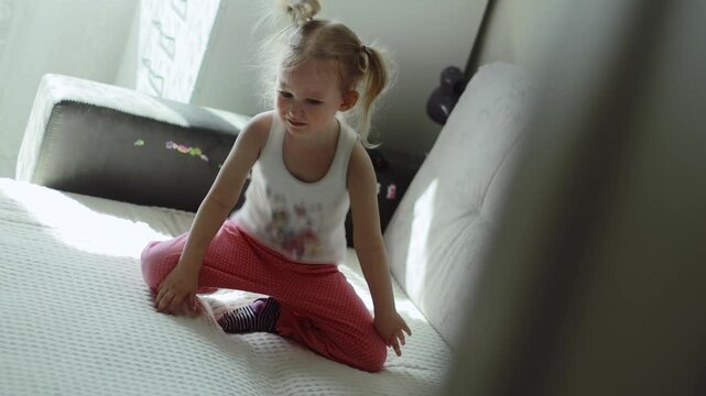 Four-year-old girl gets angry and hits her hand on sofa. Nervous system disorders. Children sadness emotion, despair. Unhappy baby child is freaking out. Resentment grudge bitterness concept. Slowmo