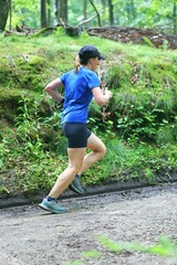 muddy Woman Running Uphill in Forest Trail