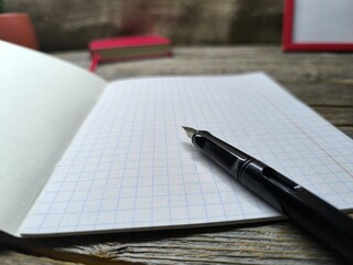 Close-up of fountain pen lying on blank notepad
