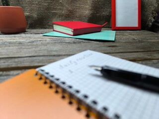 Close-up of a pen lying on a notebook with the inscription daily task